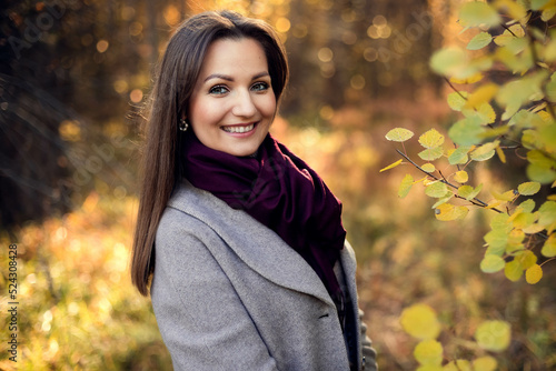 Outdoor atmospheric fashion photo of young beautiful lady. Brown hair. Warm autumn. Close up