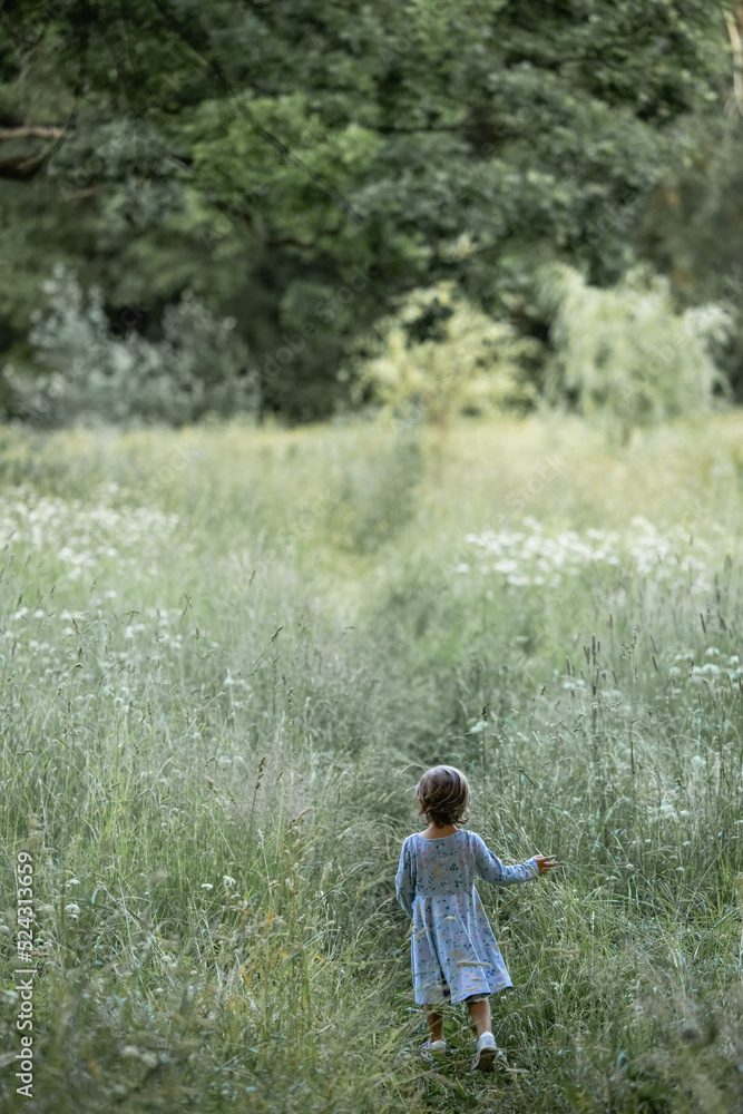 Little girl running on meadow with sunset Little girl running on meadow with sunset