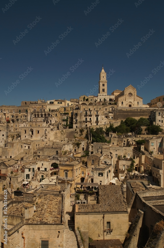 View at old buildings, walls, roofs and rock with religious cross in ancient town, Sassi de Matera, Italy.
