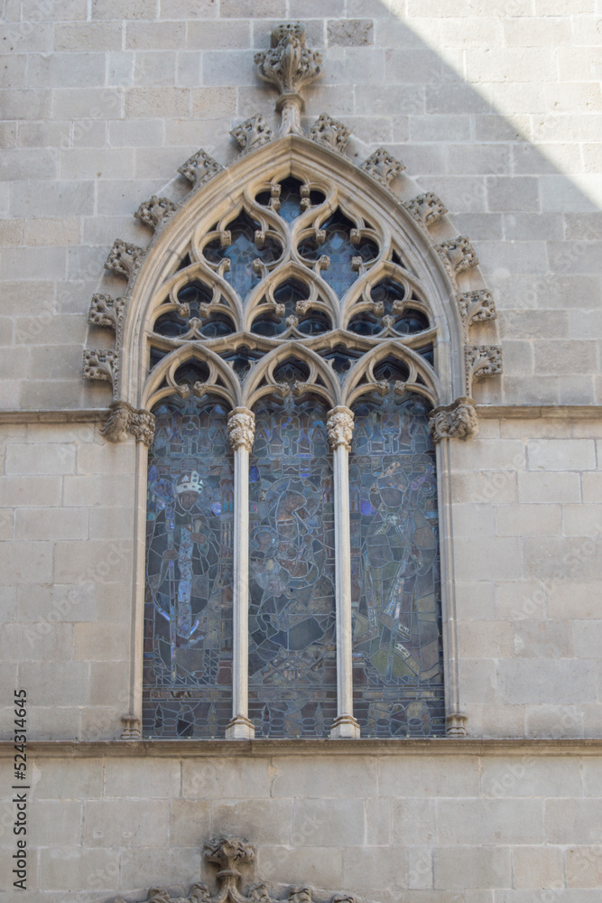 Stone flamboyant gothic arch with stained glass window in a window of the Barcelona house building in Barcelona. Spain