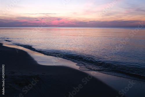 Baltic sea sunset sky  silver purple colors of sea calm water. Romantic beach landscape.
