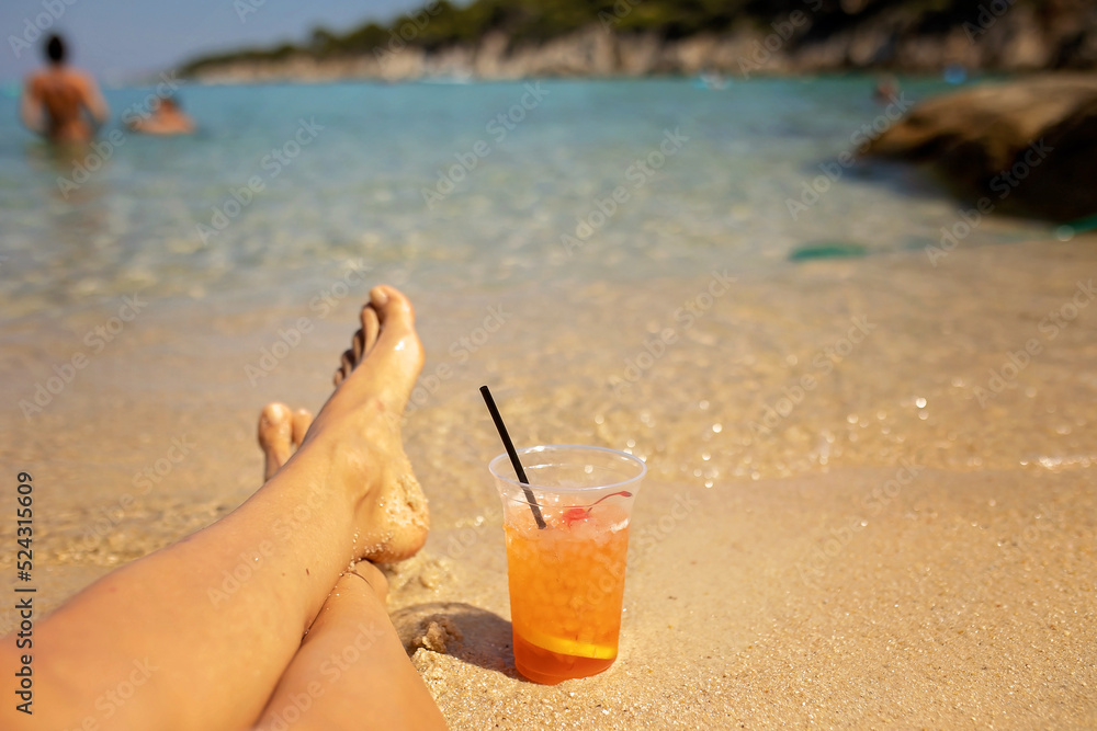 Woman on the beach, drinking coctail in the water, enjoying summer