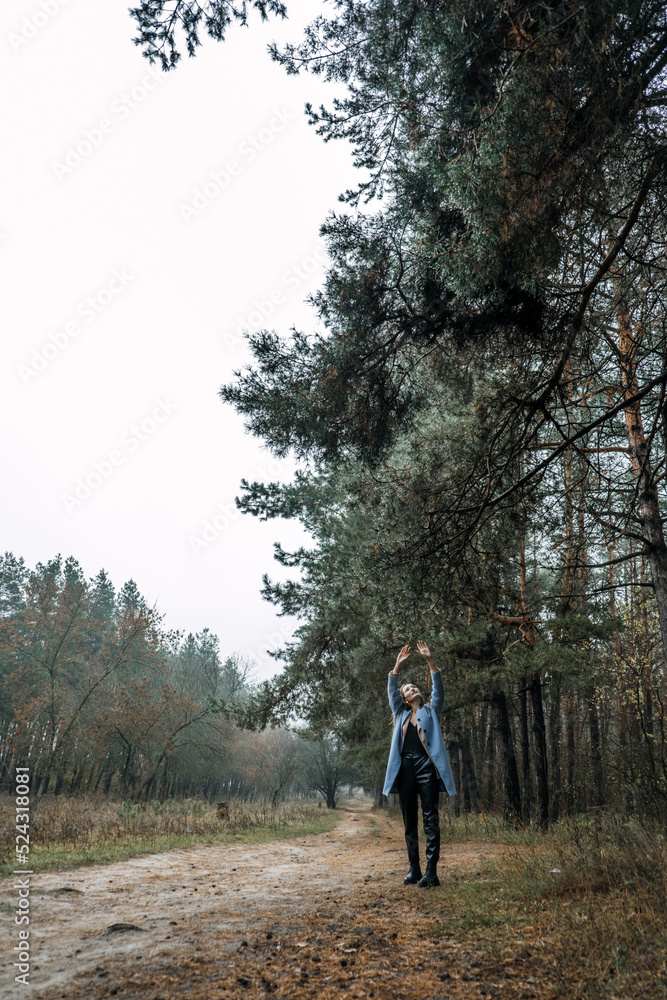 Improving mental wellbeing, Relax and reduce stress. young woman in red sweater touching water drops on tree branches Improving mental wellbeing, Relax and reduce stress. young woman in red sweater touching water drops on tree branches