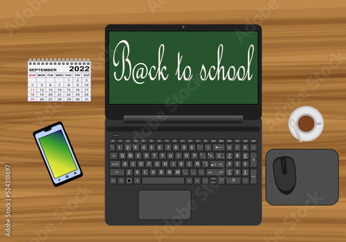 La vuelta al cole online escrito en la pantalla de un ordenador portátil, portátil, móvil, calendario, ratón inalámbrico, alfombrilla y taza de cacao con cucharilla sobre una mesa de madera