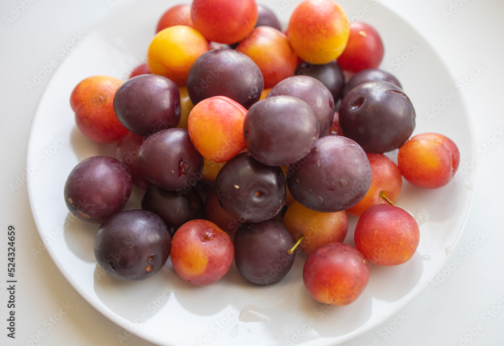 new harvest, plums on a white plate. Isolate, natural fruit dessert. Delicious, healthy snack, a piece of summer, harvest. Fruits on white, fruit plate of plums new harvest, plums on a white plate. Isolate, natural fruit dessert. Delicious, healthy snack, a piece of summer, harvest. Fruits on white, fruit plate of plums