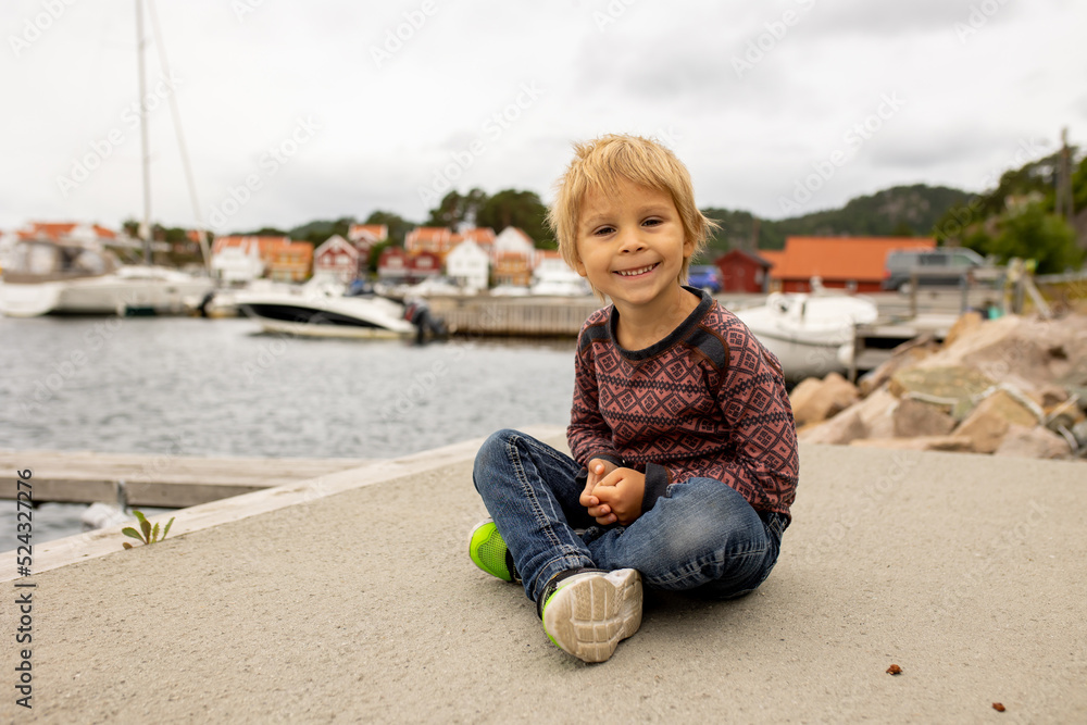 Toddler child, enjoying the view over beautiful small village in south Norway Toddler child, enjoying the view over beautiful small village in south Norway
