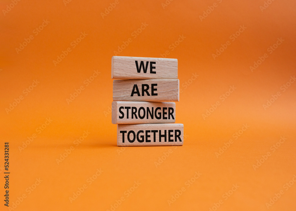 We are stronger together symbol. Wooden blocks with words We are stronger together. Beautiful orange background. We are stronger together concept. Copy space. - obrazy, fototapety, plakaty 