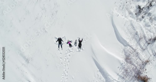 happy family lies in the snow and makes an angel