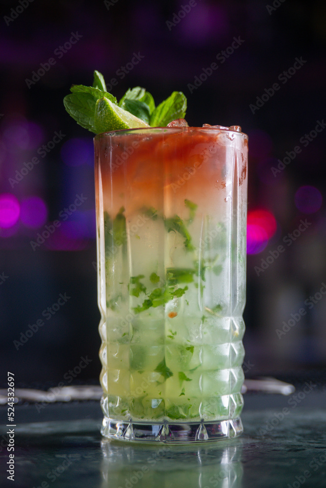 cocktail with lime and herbs on a marble table of a bar cocktail with lime and herbs on a marble table of a bar
