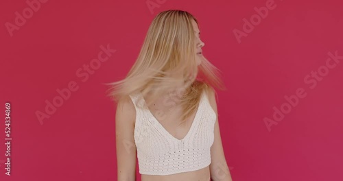 Young woman with long hair wearing white t shirt waving hair