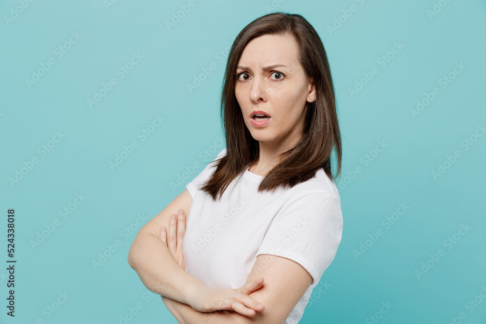 Side view young indignant caucasian woman 20s she wear white t-shirt hold hands crossed folded look camera isolated on plain pastel light blue cyan background studio portrait People lifestyle concept Side view young indignant caucasian woman 20s she wear white t-shirt hold hands crossed folded look camera isolated on plain pastel light blue cyan background studio portrait People lifestyle concept