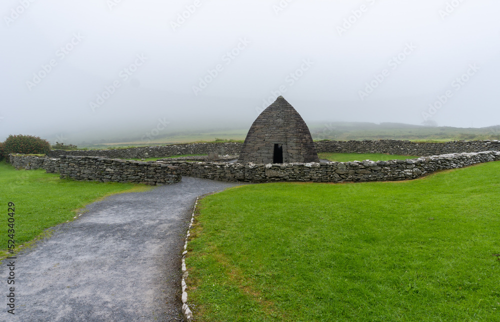 landscape view of the Gallarus Oratory early-Christian church in County Kerry on a foggy morning