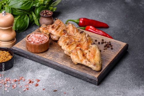 Baked chicken wings with sesame seeds and sauce on a wooden cutting board