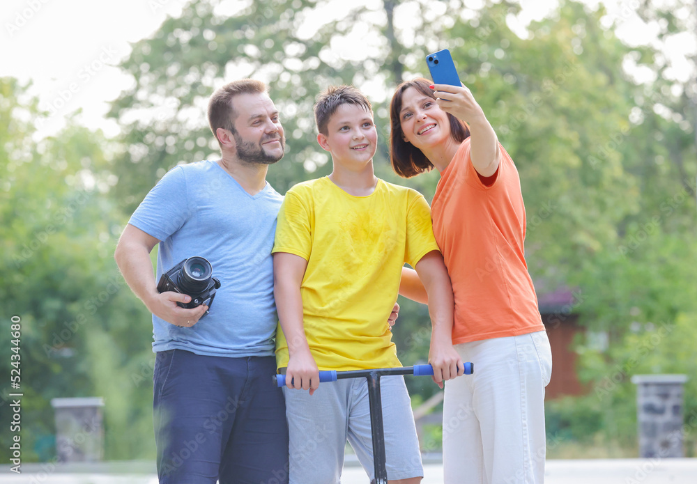 happy family takes a selfie on the background of nature.dad mom and son take a selfie using a smartphone happy family takes a selfie on the background of nature.dad mom and son take a selfie using a smartphone