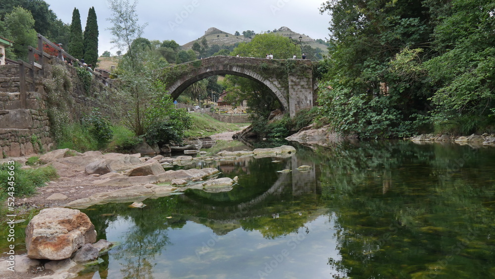La rivière de la légende de l'homme poisson, dans le village de Lierganes, rivière verte, transparente, liquide, avec de la végétation, des arbres et une promenade détente et pont historique