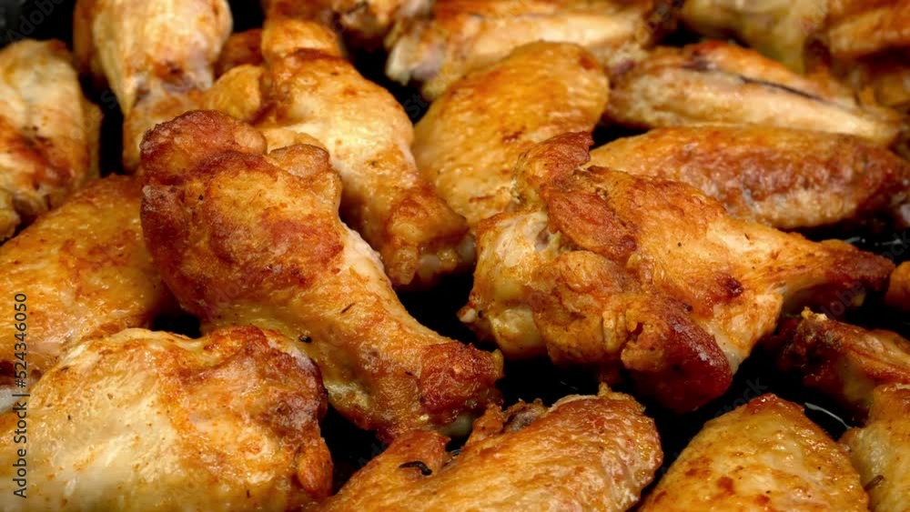 Many fried, sliced chicken wings, with crispy crust rotate slowly. Many fried, sliced chicken wings, with crispy crust rotate slowly.
