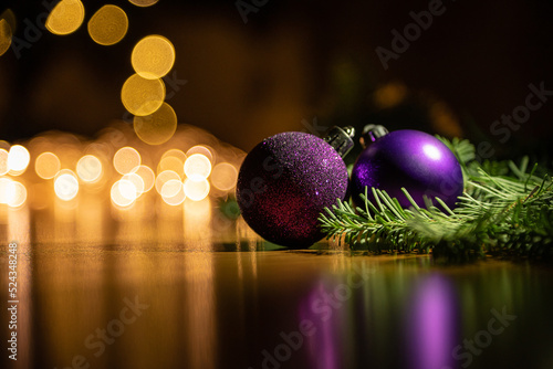 Purple Christmas balls lie on the background of garland lights. New Year's background