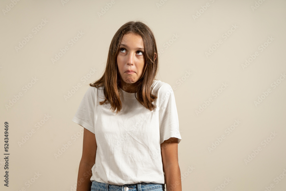 A young Latin brunette woman isolated for blue background shrugs her shoulders and widens her eyes in confusion. A young Latin brunette woman isolated for blue background shrugs her shoulders and widens her eyes in confusion.