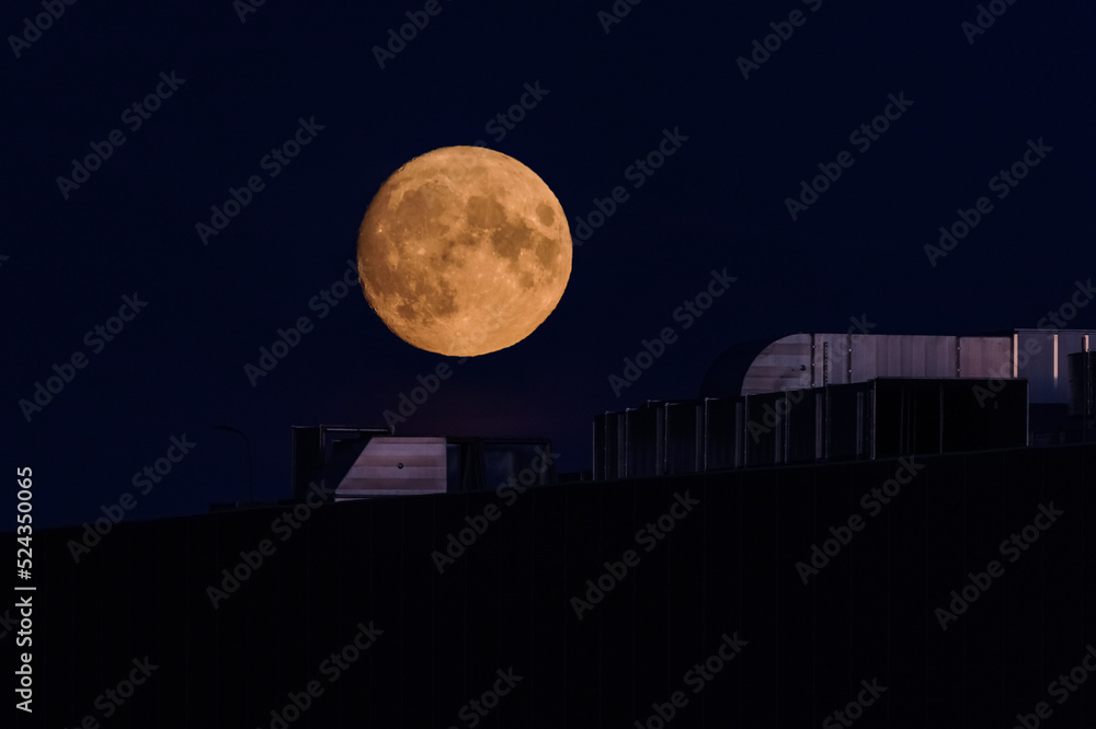 MOON - Earth satellite over the roof of a shopping mall and against the night sky