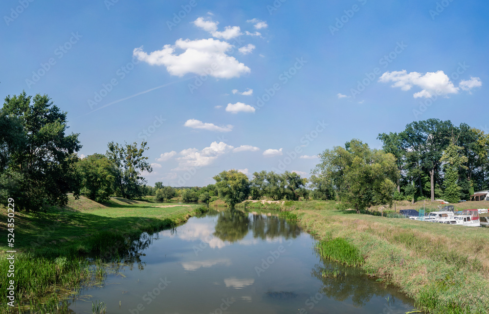 Rzeka Osobłoga, w tle lekko pochmurna pogoda, błękit nieba zieleń przy brzegu, pora letnia, Osobłoga w odcinku województwa Opolskiego Rzeka Osobłoga, w tle lekko pochmurna pogoda, błękit nieba zieleń przy brzegu, pora letnia, Osobłoga w odcinku województwa Opolskiego