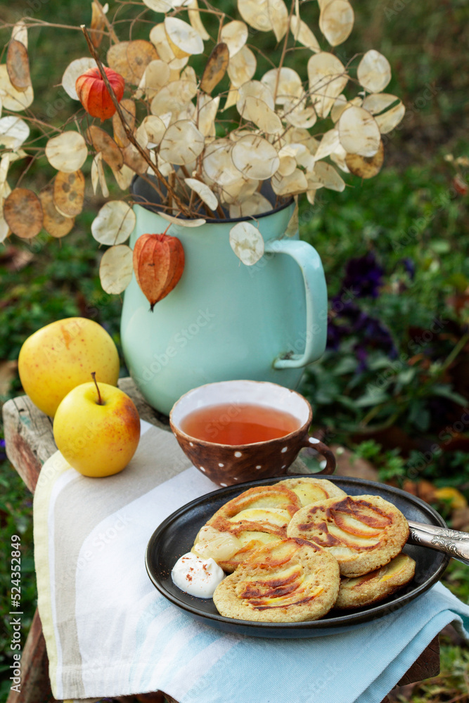 Whole wheat apple pancakes served with tea in the garden. Rustic style.