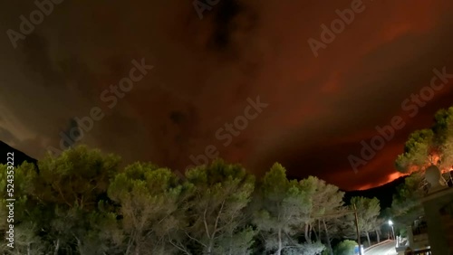 4k timelapse of a storm with red clouds reflecting a Forest fire in Bejis, Spain. The video is taken in Gatova village