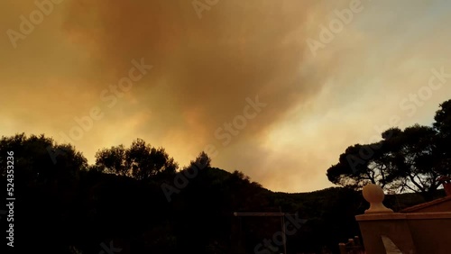 4k timelapse of a sun completely covered by a column of smoke from a forest fire in Bejis, Spain. The video is taken in Gatova village