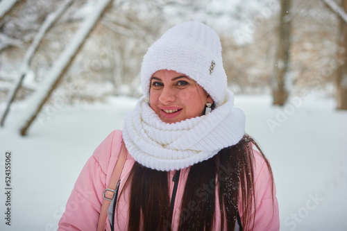 Portrait of a white girl in a white hat in the winter forest. Horizontal photo. High quality photo