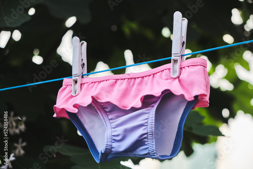 Obraz na plátně Maillot de bain enfant en train de sécher sur une corde à linge.