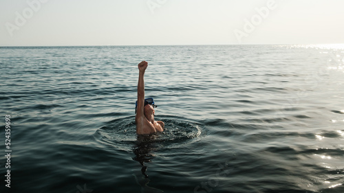 Kid in the sea doing super hero pose. photo