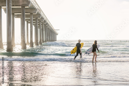 surfers walking on the beach photo