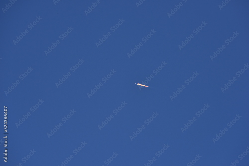 Distant Rocket Launch clear Blue Day with exhaust trail and sunny sky Distant Rocket Launch clear Blue Day with exhaust trail and sunny sky