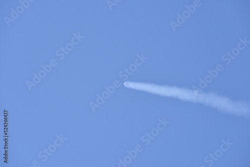 Distant Rocket Launch clear Blue Day with exhaust trail and sunny sky