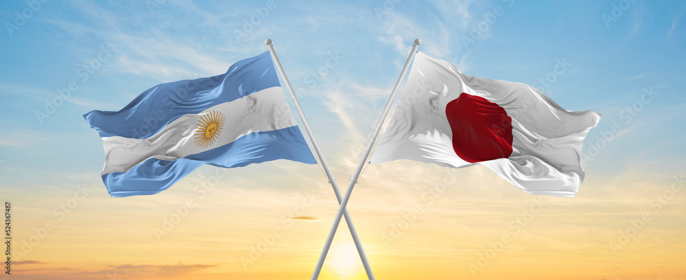 crossed national flags of Argentine and japan flag waving in wind at ...