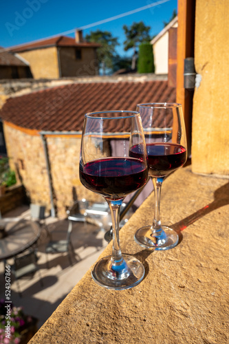 Tasting of red wine by old wine maker in Pierres Dorées region with yellow stone houses on south of Beaujolais region, France photo