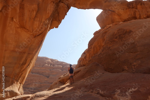 Hombre de viaje viendo al horizonte enmarcado por una roca