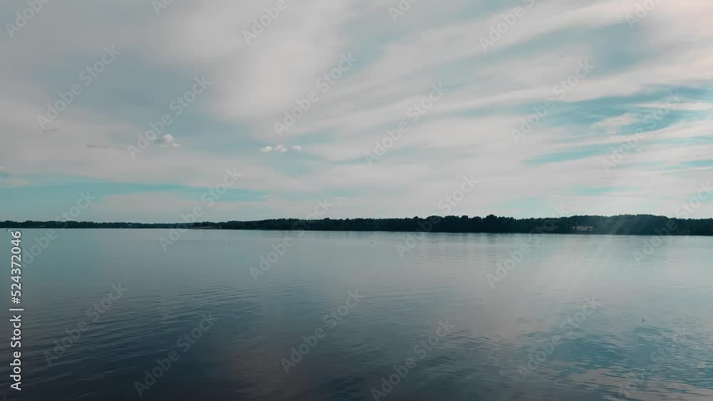 A smooth panorama of a calm wide river. Green shores and blue sky A smooth panorama of a calm wide river. Green shores and blue sky