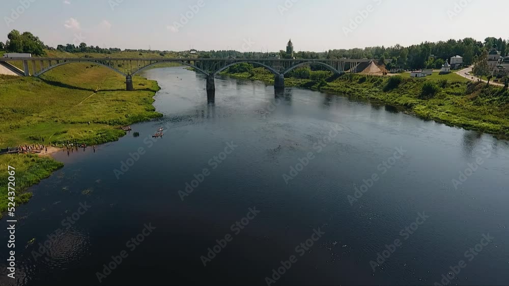 Shooting from a drone of a river and a bridge over it in good summer weather. Wonderful shots of a small town Shooting from a drone of a river and a bridge over it in good summer weather. Wonderful shots of a small town