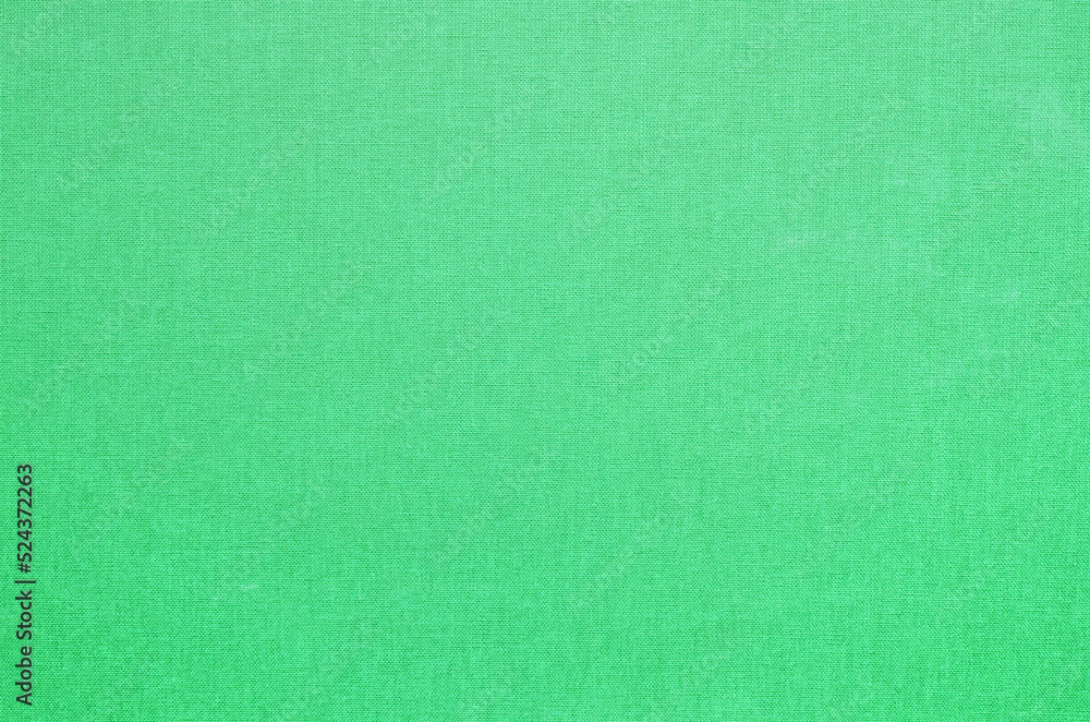 Close-up texture of natural weave cloth. Emerald green fabric background. Natural cotton textile material. Close-up texture of natural weave cloth. Emerald green fabric background. Natural cotton textile material.