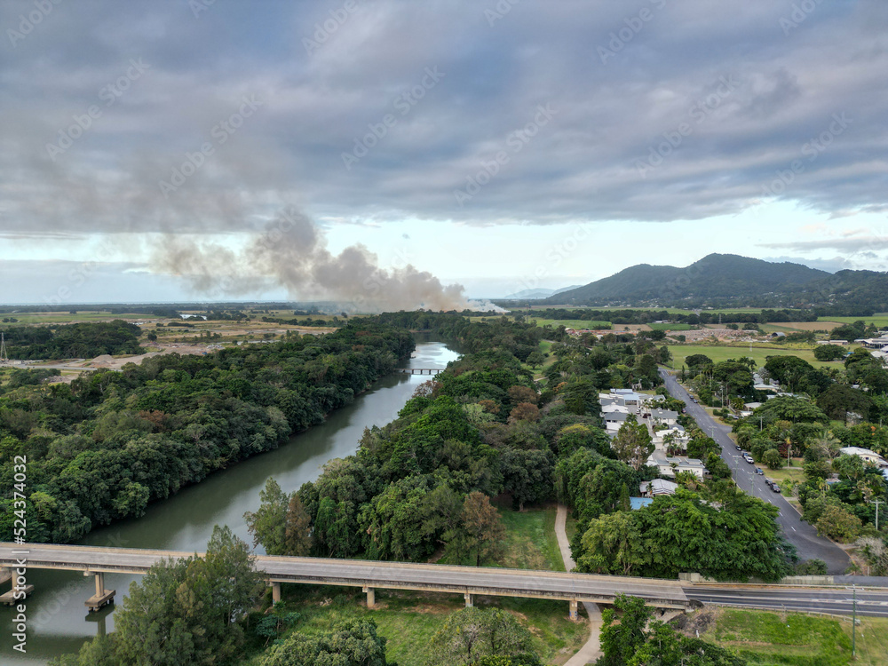 Aerial view of bridge over river and tropical living with smoke in the background Aerial view of bridge over river and tropical living with smoke in the background