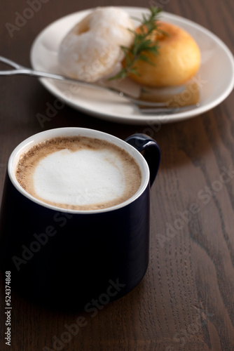 hot coffee with donuts on wooden table