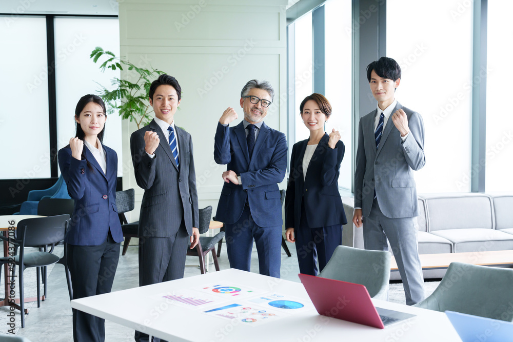 オフィスでガッツポーズを取るビジネスパーソン オフィスでガッツポーズを取るビジネスパーソン