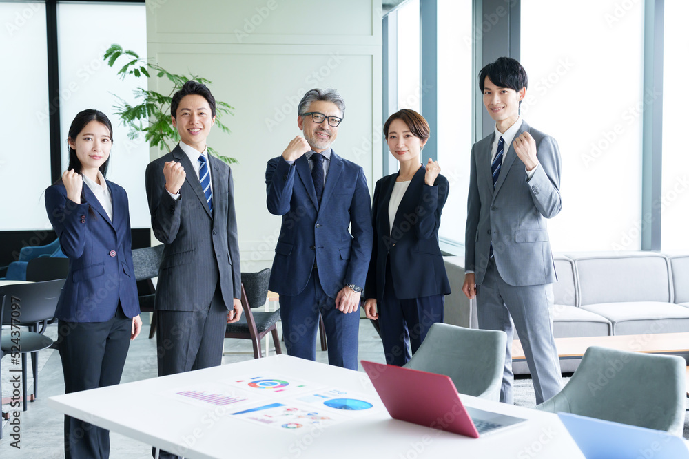 オフィスでガッツポーズを取るビジネスパーソン オフィスでガッツポーズを取るビジネスパーソン