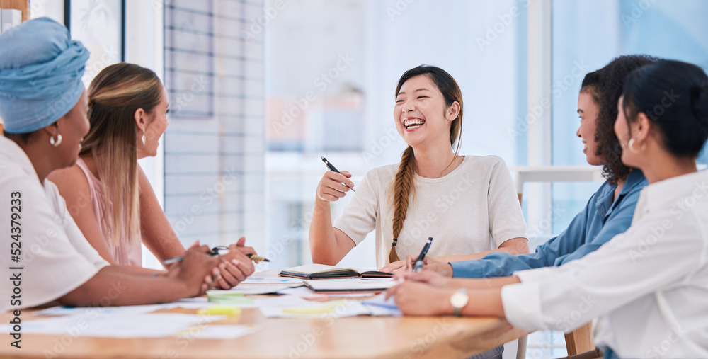 Fototapeta premium A diverse business team of females only in a meeting laughing and smiling due to a positive mindset, mission and vision. Group of happy and excited businesswomen planning in a boardroom