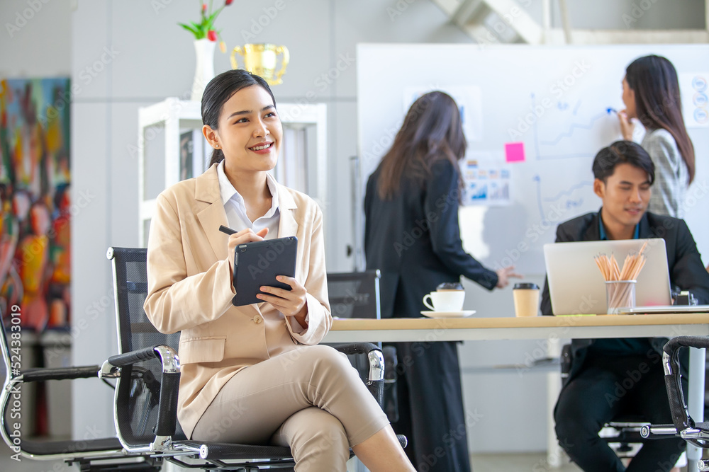 Portrait of Asian beautiful business woman working at the office, beautiful woman using touchpad with smile at working place. Portrait of Asian beautiful business woman working at the office, beautiful woman using touchpad with smile at working place.