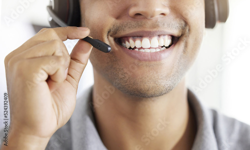 . Friednly call center, customer support or contact us employee working at telemarketing company. Closeup of happy crm worker or receptionist talking in headset in agency office.