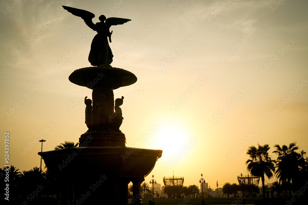 statue of a person at sunset