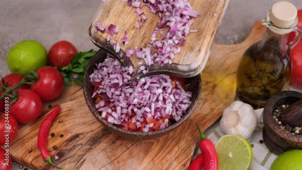 Woman pours Chopped red Onion from board to wooden bowl Woman pours Chopped red Onion from board to wooden bowl