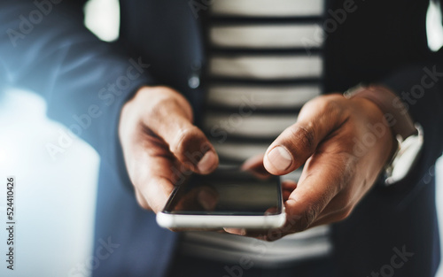 Fototapeta Naklejka Na Ścianę i Meble -  Hands of business man typing on phone, networking on social media and browsing internet at work. Closeup of a professional corporate employee checking a text, scrolling an app and reading message