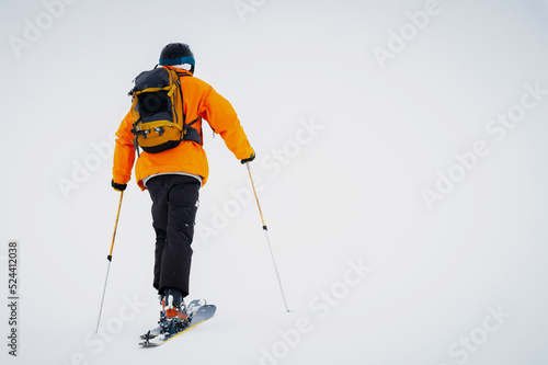 Ski tourist goes uphill. Snow and winter sports, ski touring in the mountains, entertainment